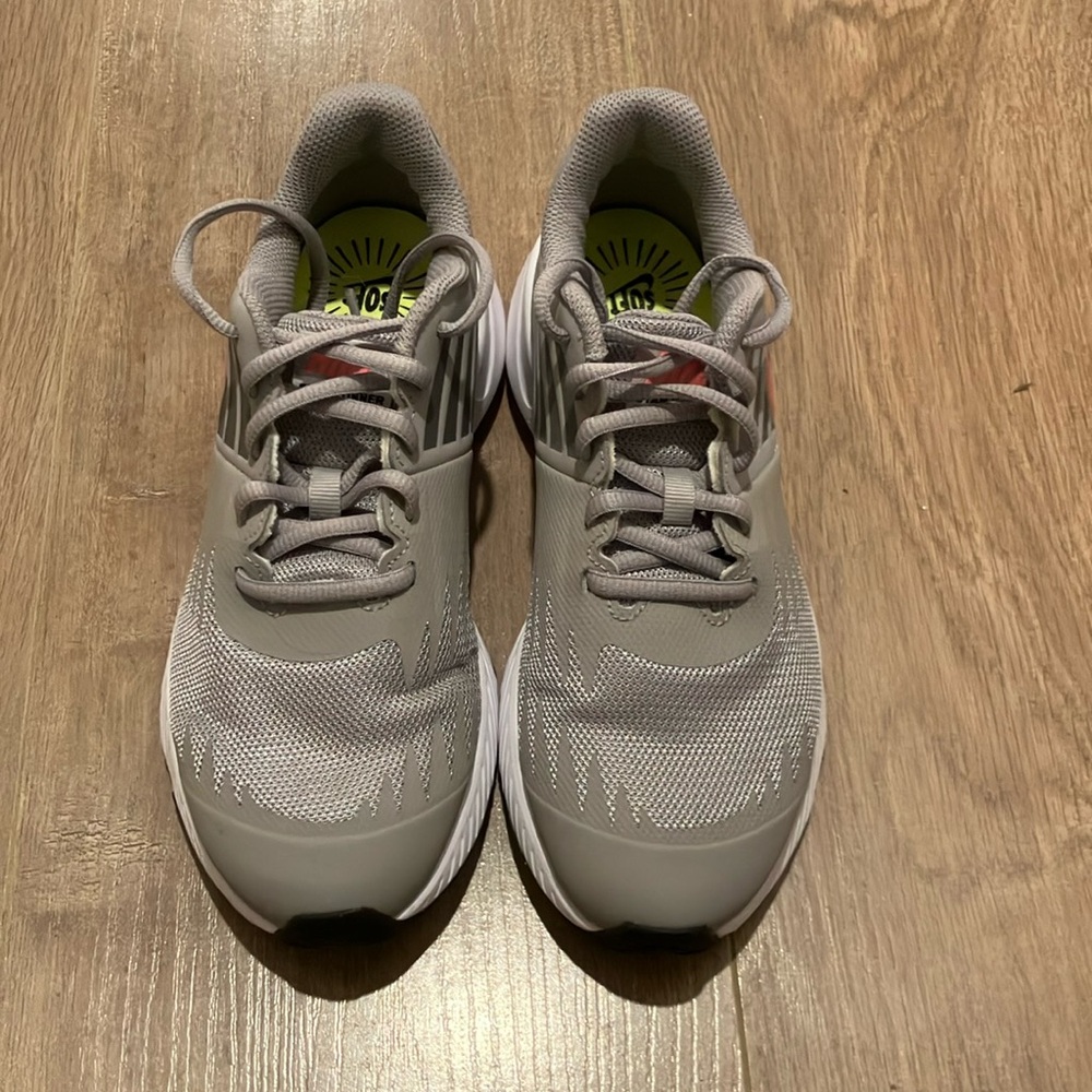 Grey Nike shoes with a pink swoosh